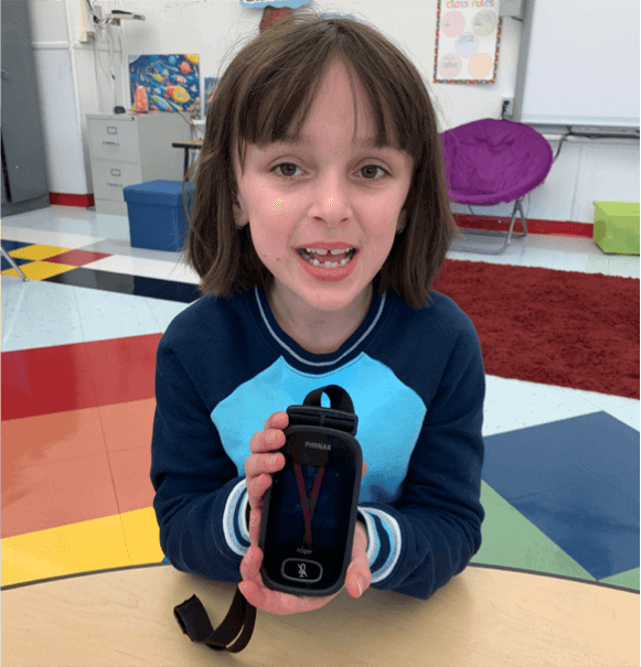 A girl holding up a water bottle in her hands.